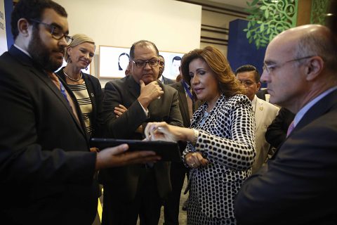 La vicepresidenta de la República, doctora Margarita Cedeño, explica cómo el Índice de Vulnerabilidad Ante Choques Climáticos (IVACC) se puede usar para ayudar a tomar decisiones que beneficien a la población que reside en zonas de alto riesgo. La tableta accede al mapa interactivo del IVACC disponible en el Work Café del “Foro Internacional Innovación para el Desarrollo Sostenible: Una Nueva Generación de Políticas Sociales”. Le acompañan, entre otros, el director regional para Latinoamérica  y el Caribe del Programa de las Naciones Unidas para el Desarrollo (PNUD), Luis Felipe López Calva; e Inka Mattila, representante de ese organismo en República Dominicana.
